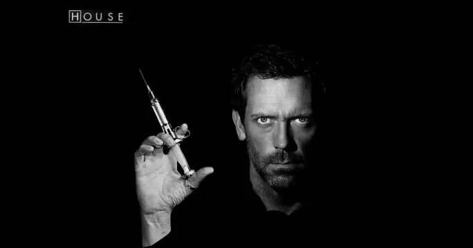  A man, Gregory House MD, holding a medical Syringe in his hand.