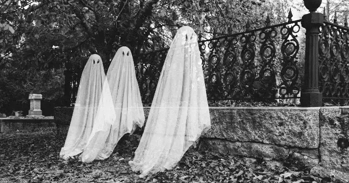 Three ghostly white figures dangling from a fence, capturing the haunting essence of the Enfield Poltergeist phenomena.