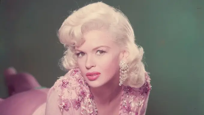 Jane Mansfield in a pink dress and earrings, exuding glamour, reminiscent of her iconic style.