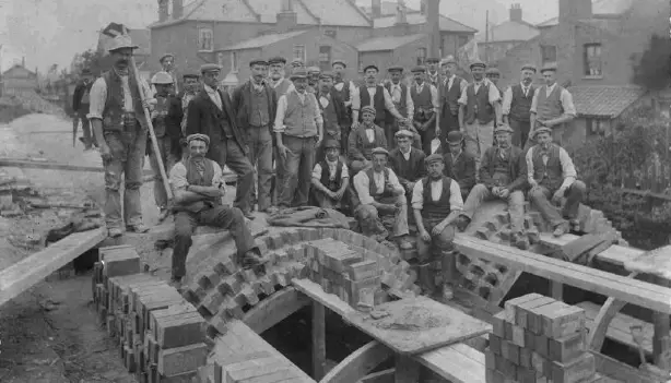 Men standing near a brick sewer, workers were involved in the construction of Joseph Bazalgette's sewage system.