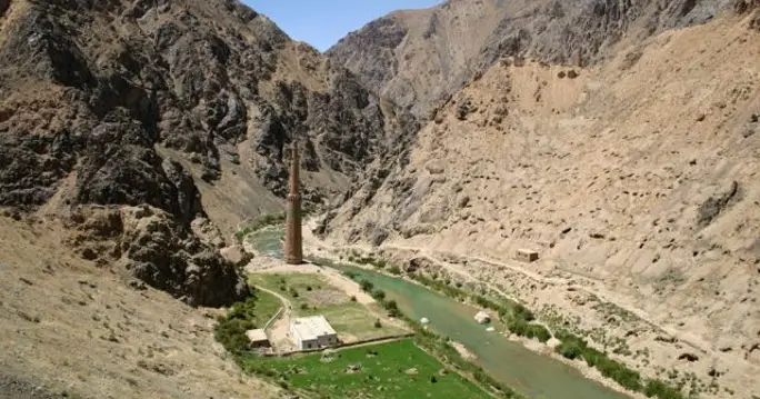 1. A scenic view of the river flowing alongside the majestic Minaret and Archaeological Remains of Jam against a mountain backdrop.