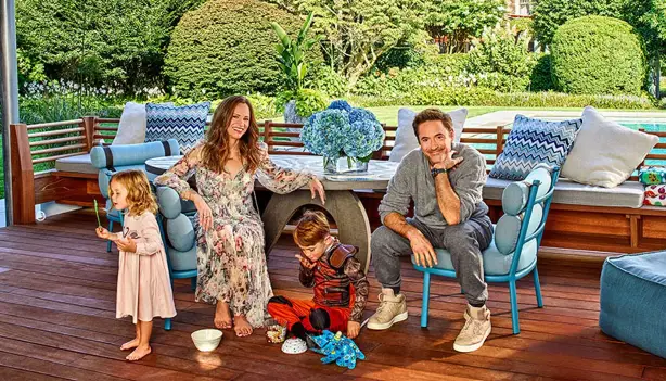 Robert Downey Jr. and family enjoys quality time together on a deck beside a sparkling pool, creating lasting memories in a sunny setting.